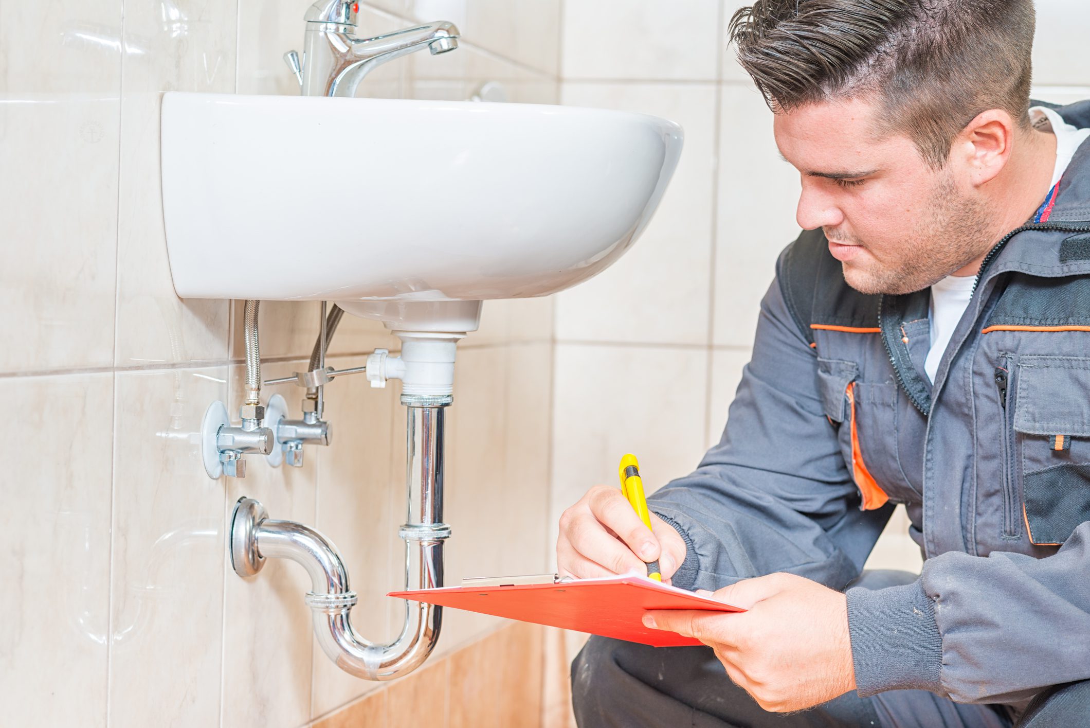 plumber looking at sink pipes