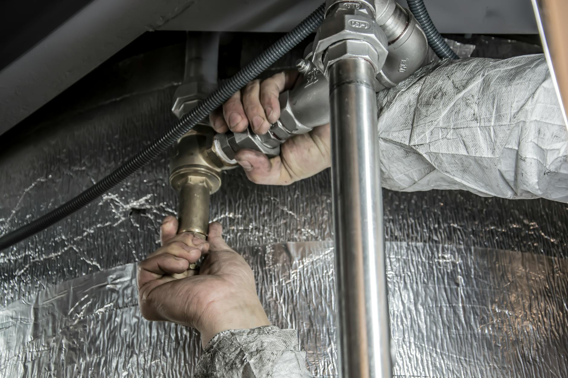 Licensed technician connecting water heater with proper expansion tank and gas fittings