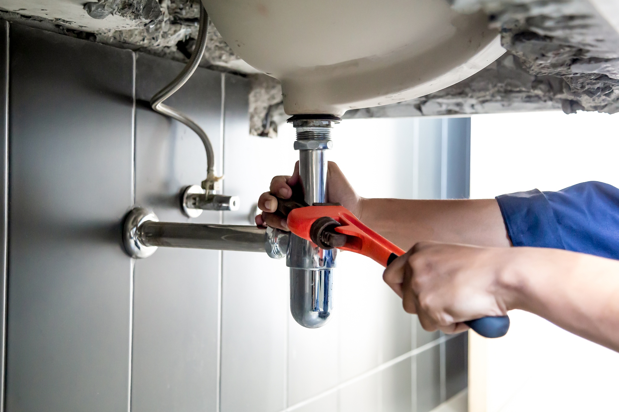 plumber works under a sink
